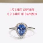 Ring with a pear-cut blue sapphire surrounded by a diamond halo on a silver band; labeled 1.27 ct sapphire and 0.21 ct diamonds.
