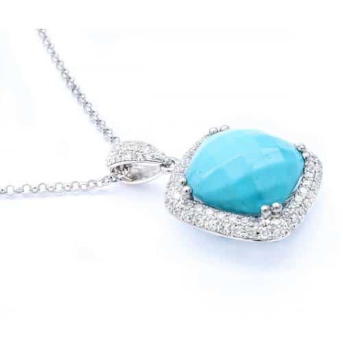 Silver necklace with a turquoise-blue cushion-cut gemstone encircled by small diamonds on a delicate chain, close-up view